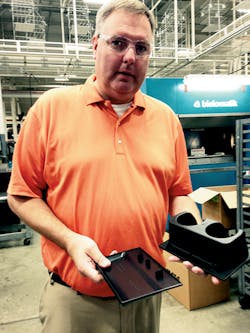 C.B. Long, operations manager, holding vibration welded parts C.B. Long, operations manager, holding vibration welded parts