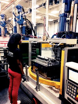 A machine operator waits for the molding cycle to finish on a vertical/vertical. A machine operator waits for the molding cycle to finish on a vertical/vertical.