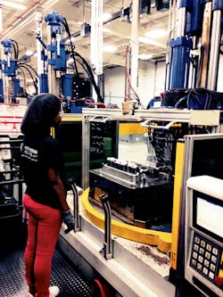 A machine operator waits for the molding cycle to finish on a vertical/vertical. A machine operator waits for the molding cycle to finish on a vertical/vertical.