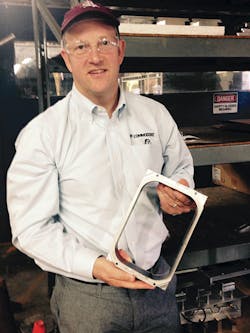 CEO Brad Braddon holds a serrated steel rule die used to cut foam trays from the web. CEO Brad Braddon holds a serrated steel rule die used to cut foam trays from the web.