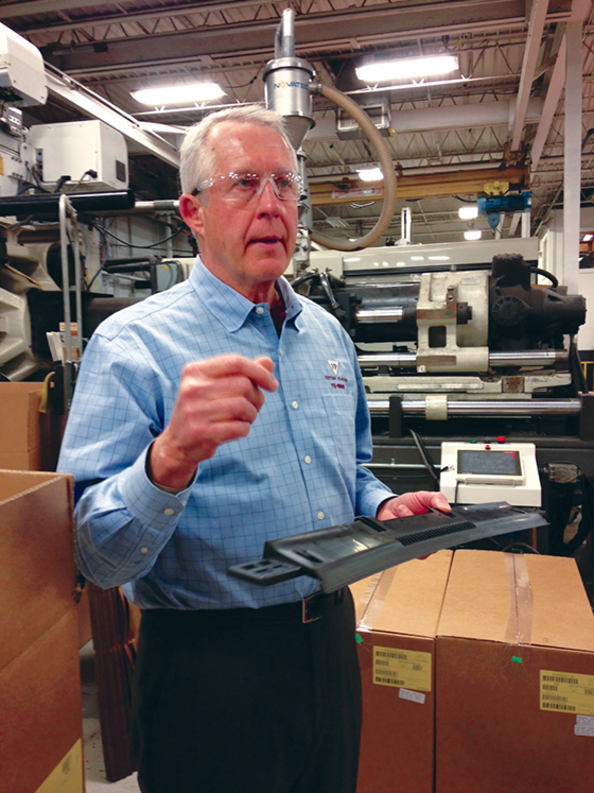 President Steve Trapp holds a sunroof guide component used by an automotive client.