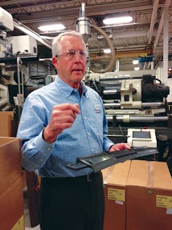 President Steve Trapp holds a sunroof guide component used by an automotive client. President Steve Trapp holds a sunroof guide component used by an automotive client.