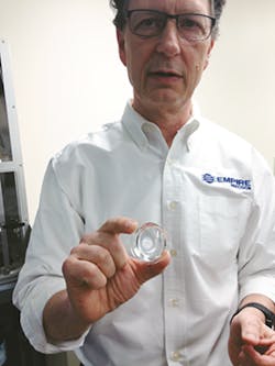 President and CEO Neal Elli holds a prototype part for a display that was single-point diamond turned President and CEO Neal Elli holds a prototype part for a display that was single-point diamond turned