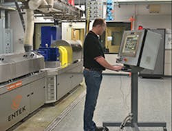 An Entek operator works at the control system for an Entek twin-screw extruder. An Entek operator works at the control system for an Entek twin-screw extruder.