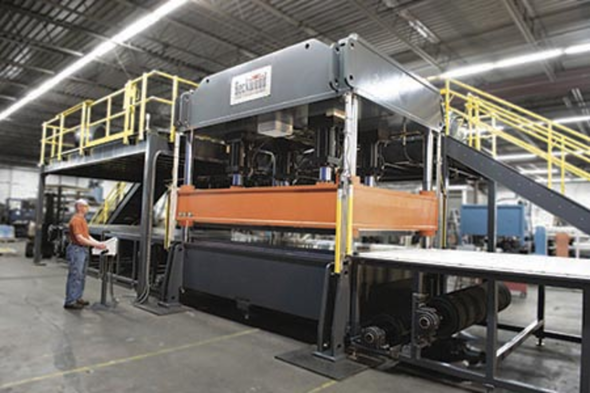 A Beckwood custom hydraulic compression molding press with automatic feeding via conveyor