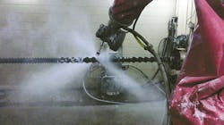 A robot cleans a screw using a high-pressure water jet. A robot cleans a screw using a high-pressure water jet.
