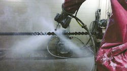 A robot cleans a screw using a high-pressure water jet. A robot cleans a screw using a high-pressure water jet.
