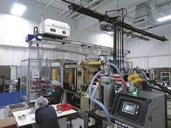 A work cell features a combination of metal-insert, two-shot injection molding with several downstream value-added operations.. A work cell features a combination of metal-insert, two-shot injection molding with several downstream value-added operations..