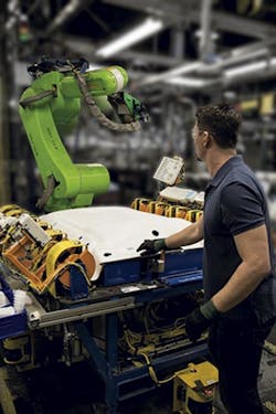A worker reaches into a work cell that includes a Fanuc CR-35iA collaborative robot. A worker reaches into a work cell that includes a Fanuc CR-35iA collaborative robot.