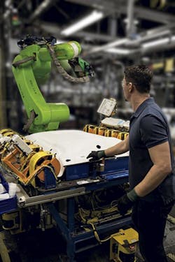 A worker reaches into a work cell that includes a Fanuc CR-35iA collaborative robot. A worker reaches into a work cell that includes a Fanuc CR-35iA collaborative robot.
