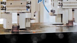 During the production of a battery cover, a robot picks up battery-terminal inserts and places them into the mold./Thomson Plastics Inc. During the production of a battery cover, a robot picks up battery-terminal inserts and places them into the mold./Thomson Plastics Inc.