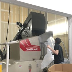 An employee uses a Cumberland grinder. An employee uses a Cumberland grinder.