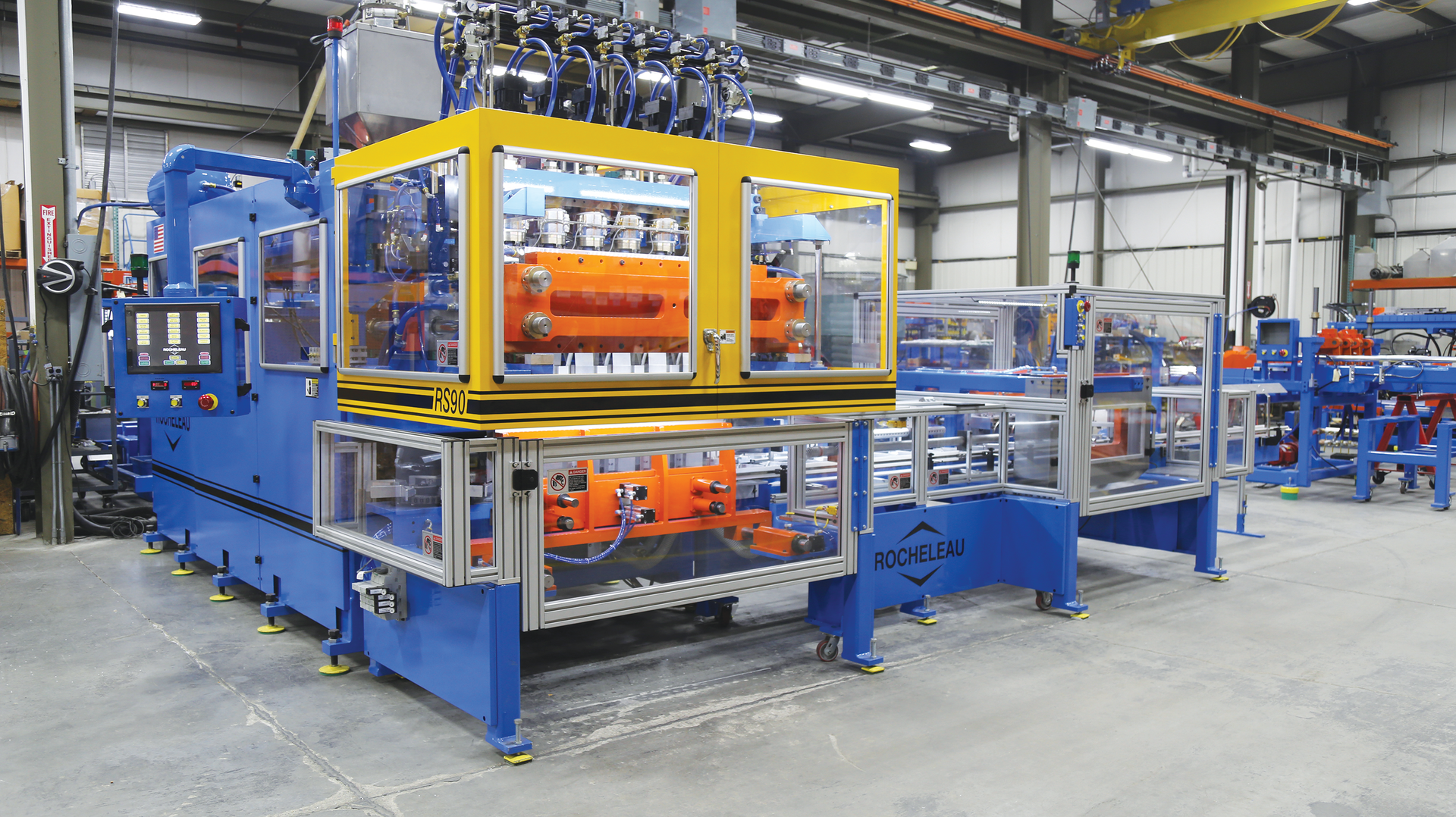 The RS-90 extrusion blow molding machine equipped with the VT-3 deflash automation package.