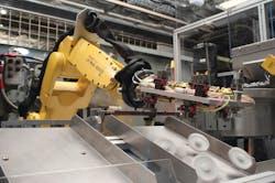 A Fanuc robotic arm handles gears. A Fanuc robotic arm handles gears.