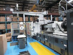 A recently installed 1,300-ton Milacron servo-hydraulic injection molding machine with a HyRobotics robot cell and a 15-ton bridge crane system overhead A recently installed 1,300-ton Milacron servo-hydraulic injection molding machine with a HyRobotics robot cell and a 15-ton bridge crane system overhead