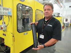 Bob Renfrew, manager of accessories production, holds a tube used on a blower that was blow molded on a Bekum machine.