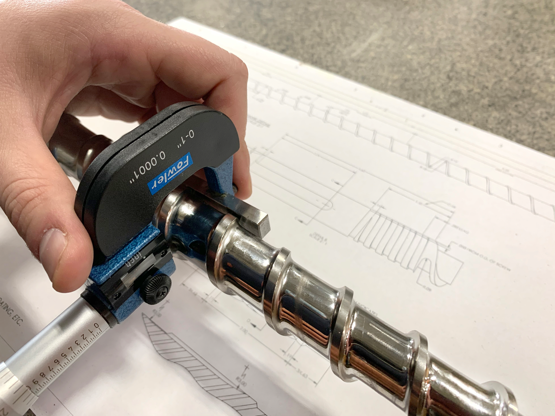 Measuring a screw for wear.