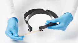 A worker shows how to assemble Evco's face shield.