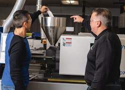 Technicians pour iD Additives' QuickShots single-dose purging compound into a machine. Technicians pour iD Additives' QuickShots single-dose purging compound into a machine.