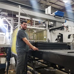 Production operator Tyler Cline receives stacks of parts at an ergonomic height in an automated production line. Production operator Tyler Cline receives stacks of parts at an ergonomic height in an automated production line.