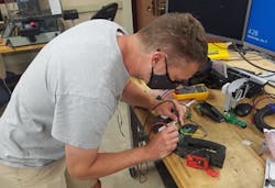 Faculty associate Joe Krachey works on powered air-purifying respirator components in the University of Wisconsin's mechatronics laboratory. Faculty associate Joe Krachey works on powered air-purifying respirator components in the University of Wisconsin's mechatronics laboratory.