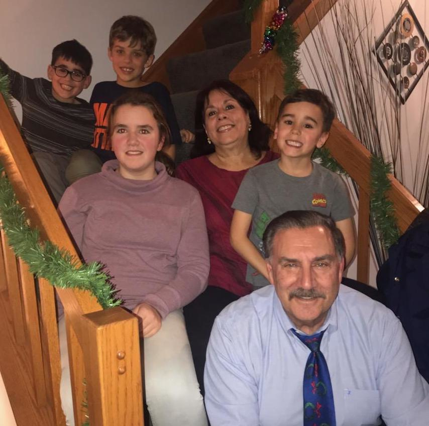 Steve Petrakis, who is retiring in June, enjoys spending time with his family, fishing and boating on a lake outside his home. Shown on the row above him at Christmas 2019 are his grandchildren, Emma and Camden; his wife, Jane; and from left to right, on the top row, grandsons, Nathan and Lincoln.