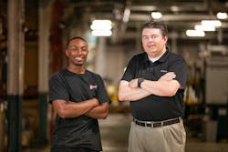 Phillip Fuller, left, and Todd Poteat, VP of manufacturing at Bright Plastics, say an apprenticeship program has paid dividends both for Fuller, who graduated from the program last year, and the company.