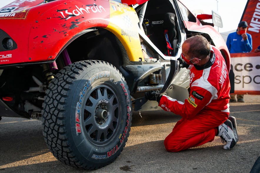 Alexandre Winocq, a co-driver who participated in the Dakar Rally, works to install a 3-D printed bracket to hold an on-board sensor in-place.