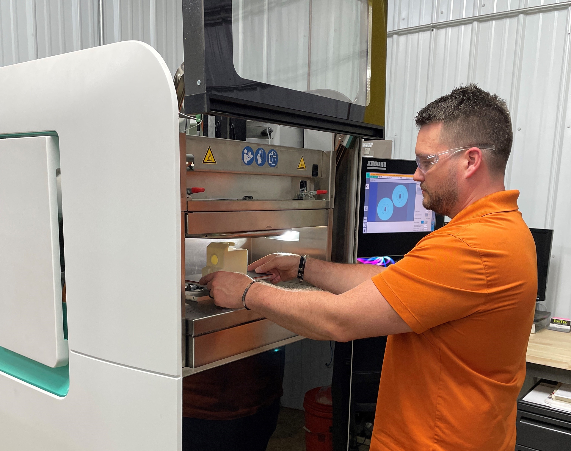 Chaz Winne, process engineer at PDS Plastics, lines up a part in the company's Arburg Freeformer.