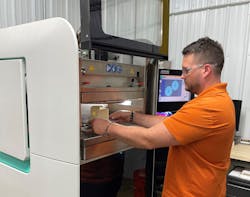Chaz Winne, process engineer at PDS Plastics, lines up a part in the company&apos;s Arburg Freeformer.