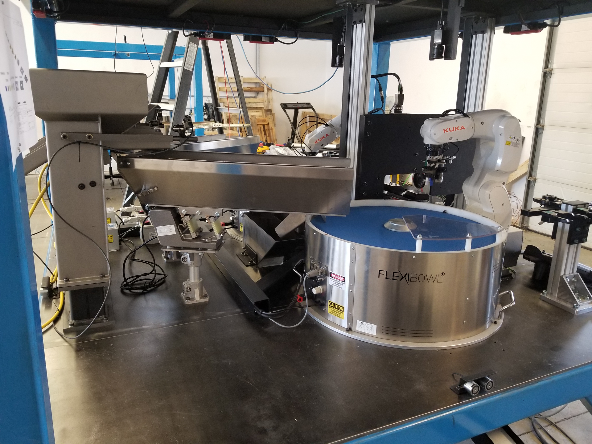 Metal and plastic automotive parts feed from a hopper into vibratory feeders, and then into programmable FlexiBowl feeders that separate the parts, allowing a robot to make picks.