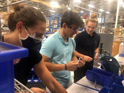 Mack interns, from left, Isabelle Nolan, Hayden Gallo and Nicole McCarvill work on a manufacturing line.