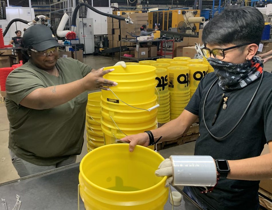 Pail maker M&amp;M Industries employees work on post-production processes. Along with Top Grade Molds and Engel, the company has been working to increase the amount of post-consumer resin it uses.