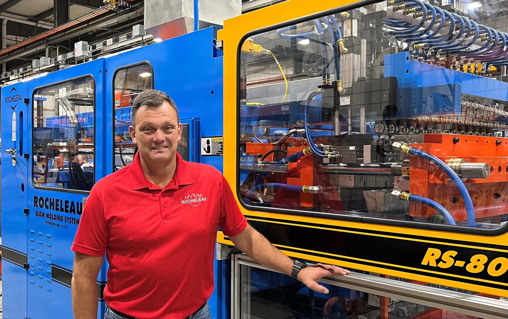 Steve Rocheleau with one of his company's extrusion blow molding machines.