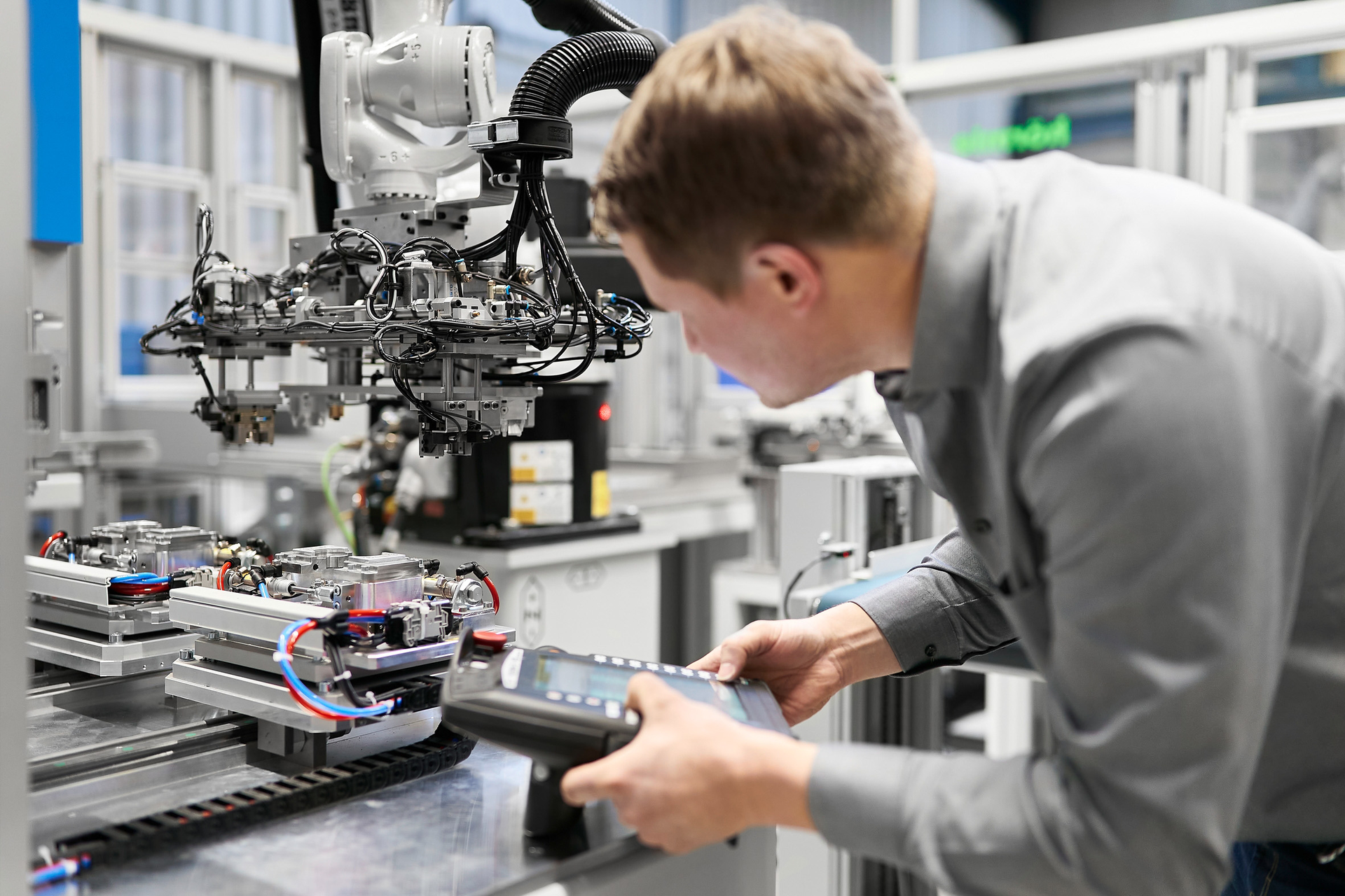 A technician looks over part of an automation cell set up by Arburg and NP Germany, an injection molder located in Brilon, Germany.