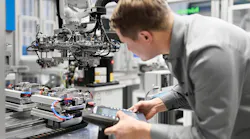 A technician looks over part of an automation cell set up by Arburg and NP Germany, an injection molder located in Brilon, Germany.