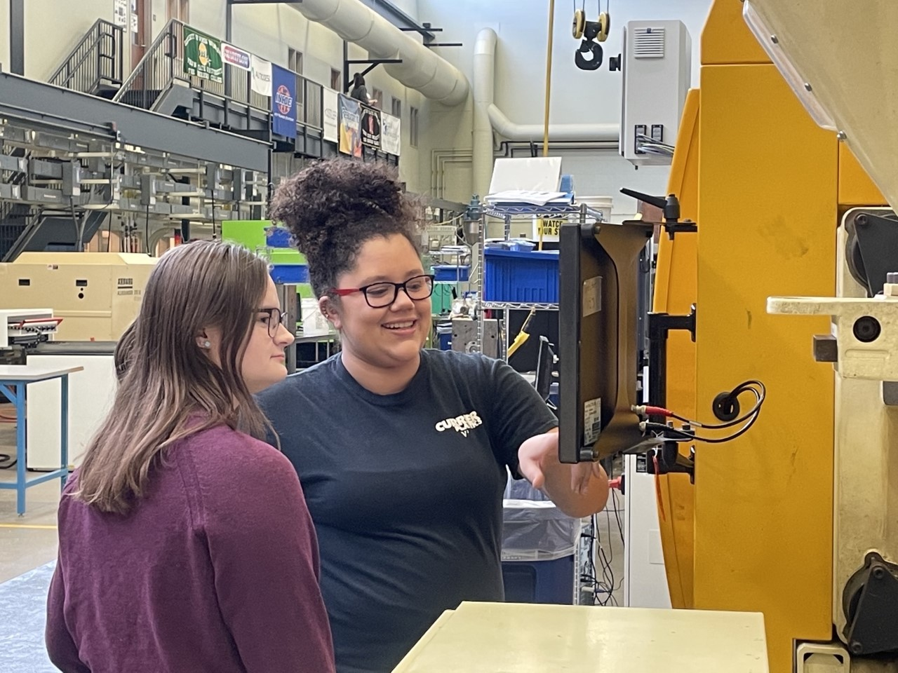College senior Jovan Heusser, right, works with a classmate on an injection molding machine at Penn State Behrend. Heusser, who has been working from home for Currier Plastics, where she's also interned, will join the Auburn, N.Y., as a full-time engineer after graduation.