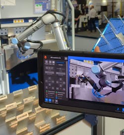 A smart device displays video of a robot, along with associated data, that’s connected to Olis Connect, as a Universal Robots robot runs in the background at Automate 2022. A smart device displays video of a robot, along with associated data, that’s connected to Olis Connect, as a Universal Robots robot runs in the background at Automate 2022.