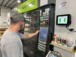An employee works at a Wintec injection molding machine at CH3 Solutions, which makes tiles for a variety of recreational playing surfaces. An employee works at a Wintec injection molding machine at CH3 Solutions, which makes tiles for a variety of recreational playing surfaces.