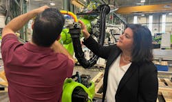 Engel North America&apos;s President Vanessa Malena watches a technician make adjustments to the end-of-arm-tool on an Engel robot arm.