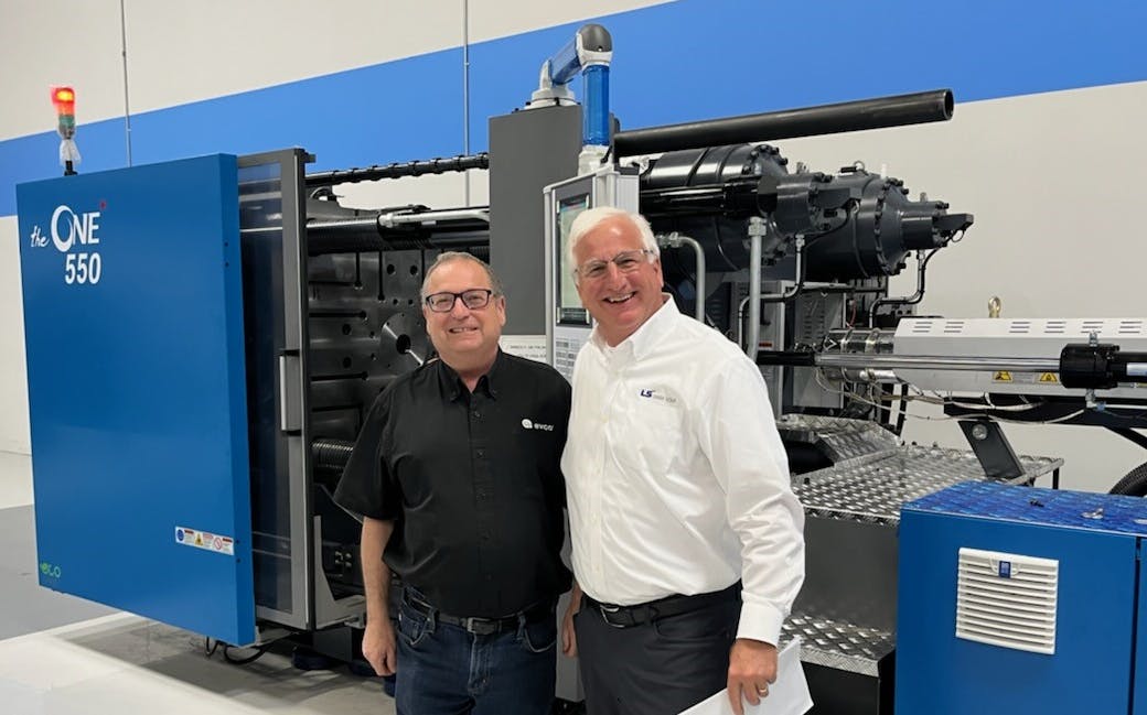 Paul Caprio, right, poses in front of an injection molding machine with Chris Evans, of Evco Plastics, a DeForest, Wis. The two men had a meeting at the Wood Dale, Ill., technical center of LS Injection Molding Machine North America.