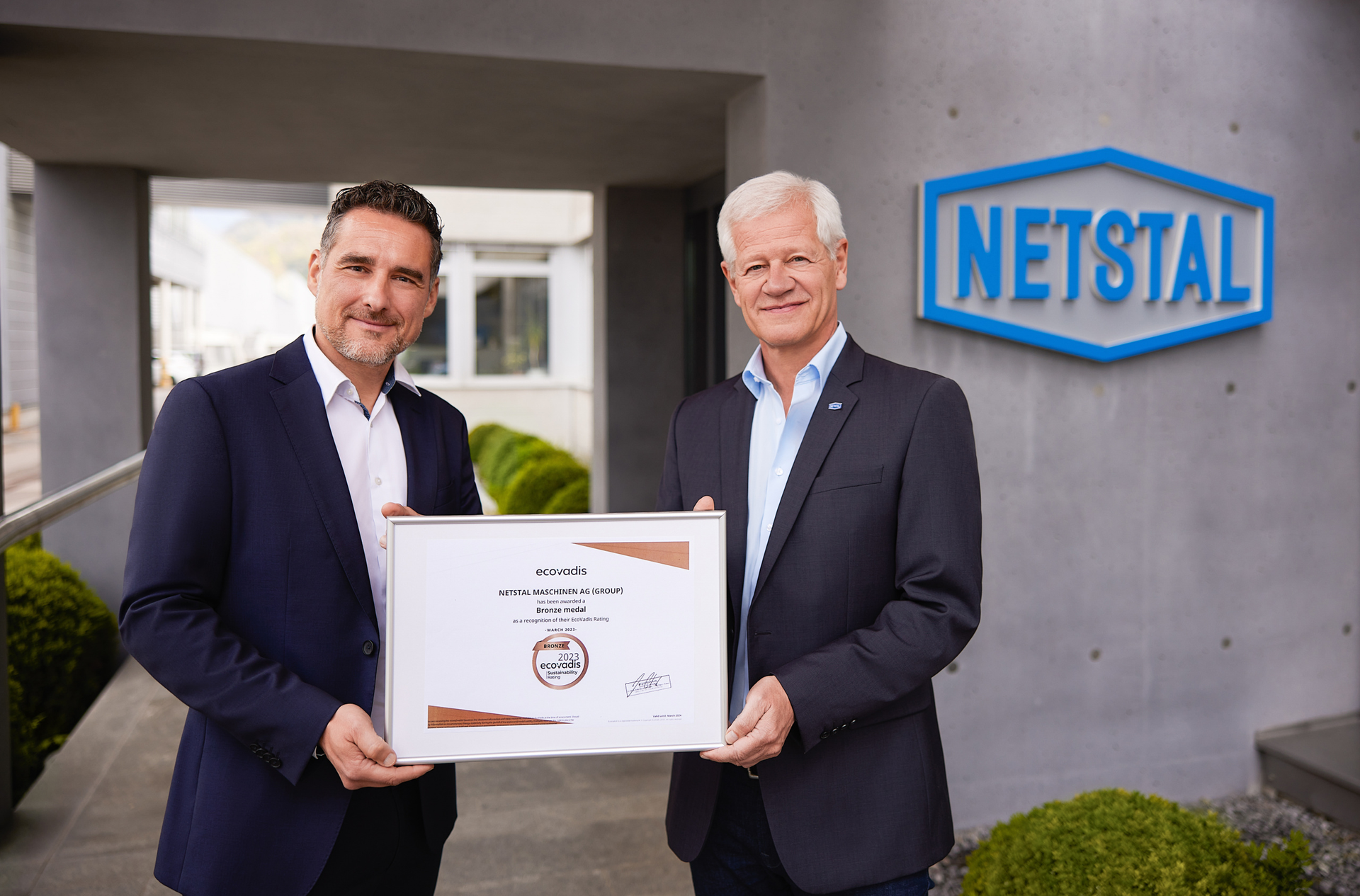 Netstal CEO Renzo Davatz, left, and Michael Rocholl, the company's head of quality and process management, display the bronze medal Netstal was awarded by EcoVadis to honor its sustainability performance.