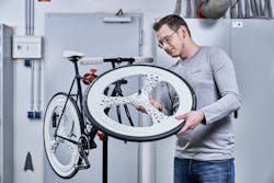 Advances in additive manufacturing make possible the production of very complex parts. Here, a man admires a bicycle&apos;s lightweight components, made by Voxeljet&apos;s VX1000 HSS 3D printer.