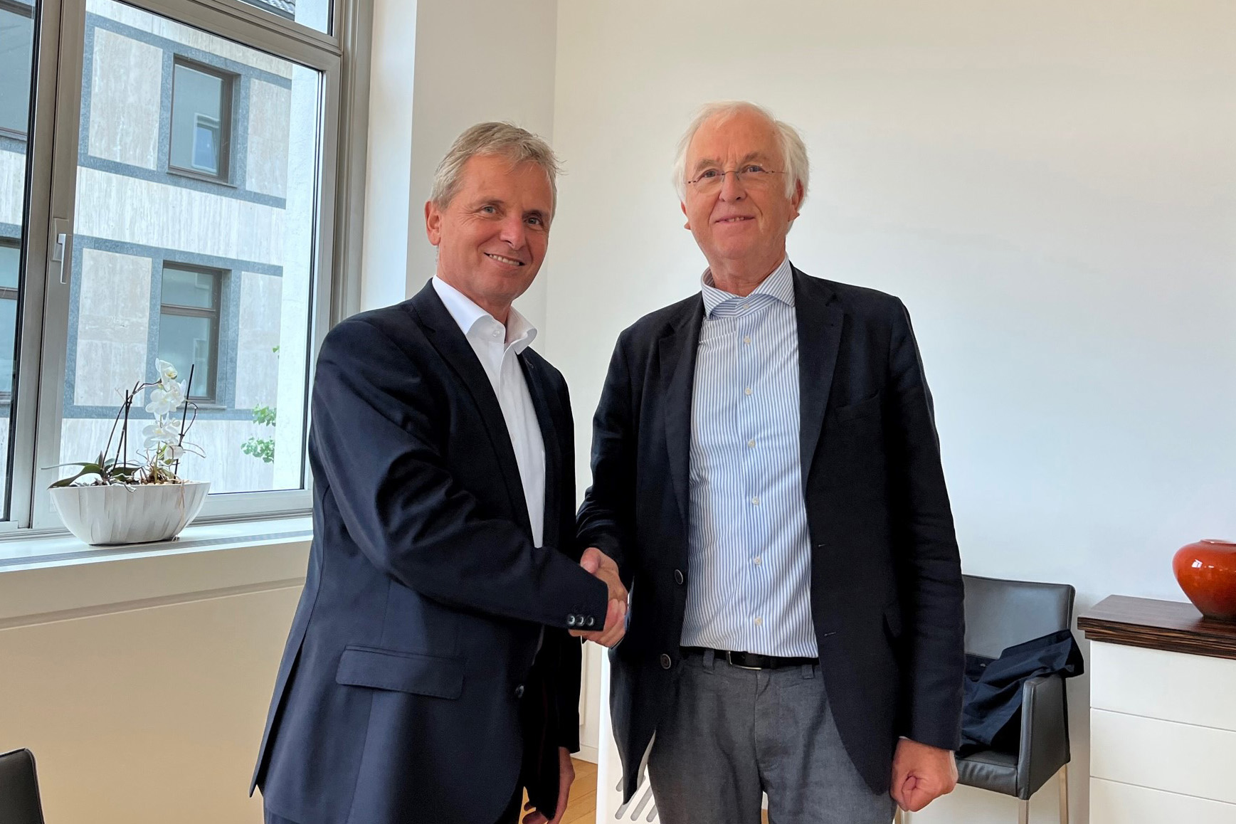 Friedrich Santner, left, and Peter E&szlig;er, owner representative of the Brabender Group, shake hands to mark Anton Paar GmbH's successful acquisition of Brabender GmbH & Co KG.