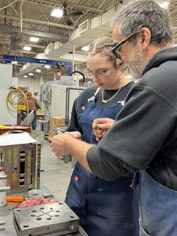 A mold maker at Stelray helps one of the company&apos;s work-based-learning staff members.