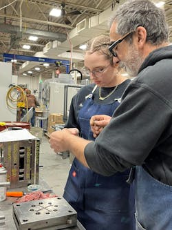 A mold maker at Stelray helps one of the company's work-based-learning staff members. A mold maker at Stelray helps one of the company's work-based-learning staff members.