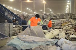 A worker sorts through carpet to be repurposed into new resin by Circular Polymers by Ascend. A worker sorts through carpet to be repurposed into new resin by Circular Polymers by Ascend.