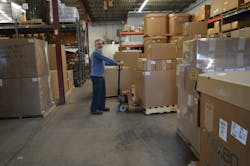 Warehouse manager Malcolm Osborne prepares to ship out a batch of fresh injection molded parts