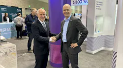 Silcotech President Michael Maloney, left, and Arburg President Martin Baumann, right, shake hands at Silcotech's booth.