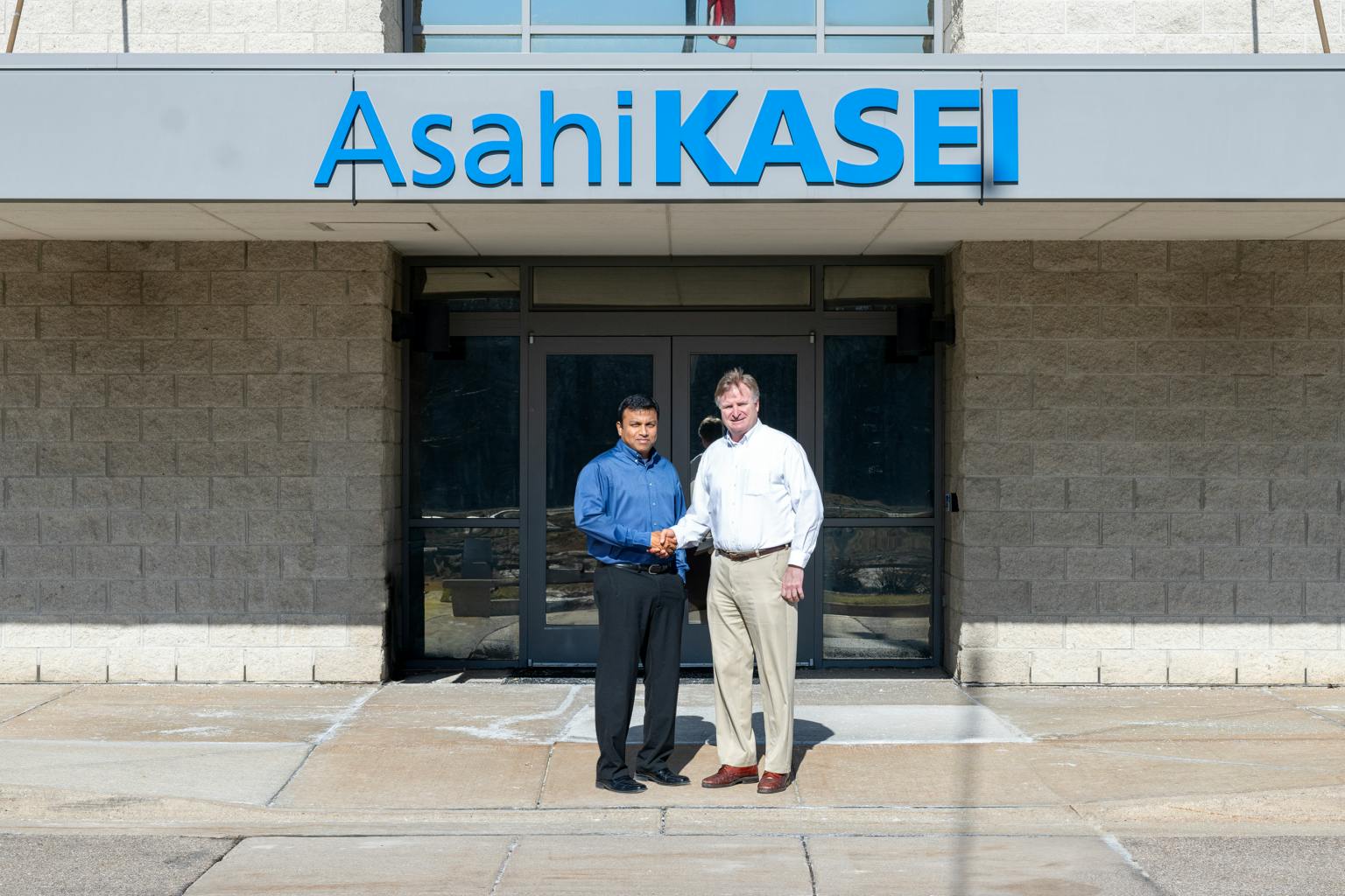 Phani Nagaraj (left) and Todd Glogovsky (right) stand in front of Asahi Kasei Plastics North America in Fowlerville, Mich.